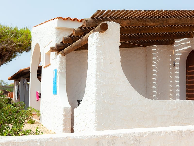 Una casa vacanza a Lampedusa con un edificio bianco e un tetto blu.