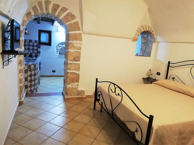 Una casa vacanza a Lampedusa con una camera da letto dotata di un comodo letto e un piccolo bagno privato.