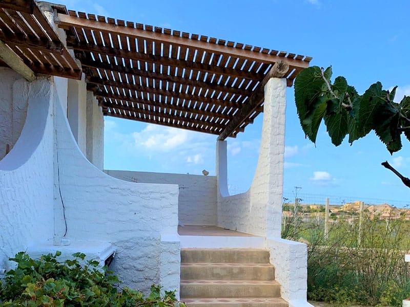 Una casa bianca con gradini che conducono ad un balcone, ideale per una casa vacanza a Lampedusa.