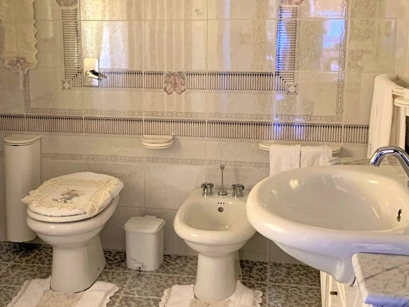 Un bagno in una proprietà case vacanze sulla bellissima isola di Lampedusa, dotato di due lavandini e wc.