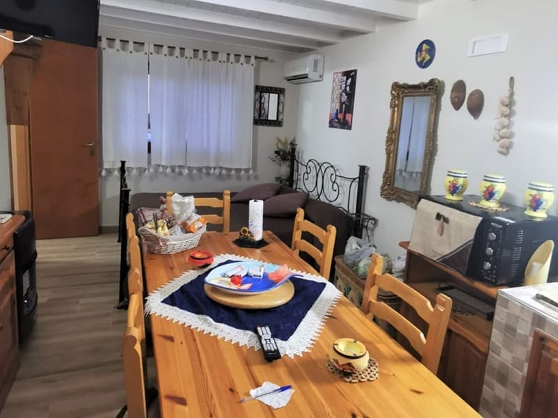 Una residenza accogliente con una piccola cucina arredata con tavolo e sedie in legno.