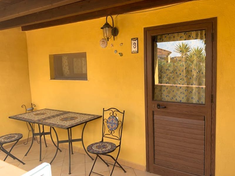 Un residence a Lampedusa con patio attrezzato con tavolo e sedie.