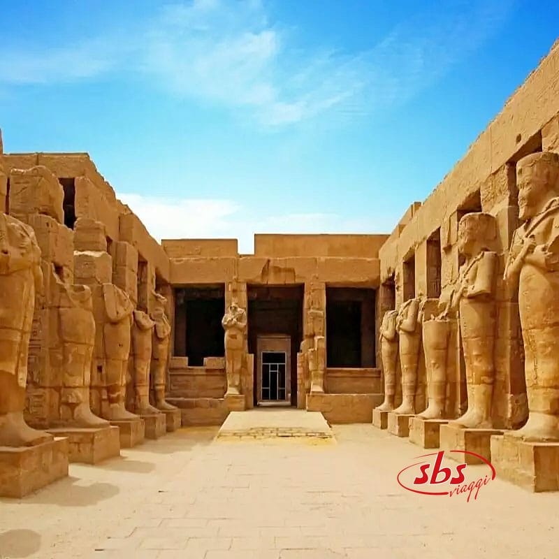 Templi egiziani con statue davanti, situati lungo il fiume Nilo.