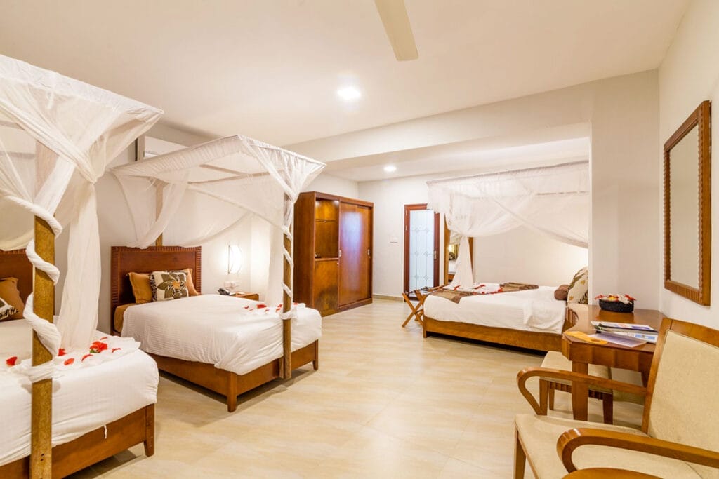 Una camera con due letti e un baldacchino al Bravo Premium Kendwa Beach.
