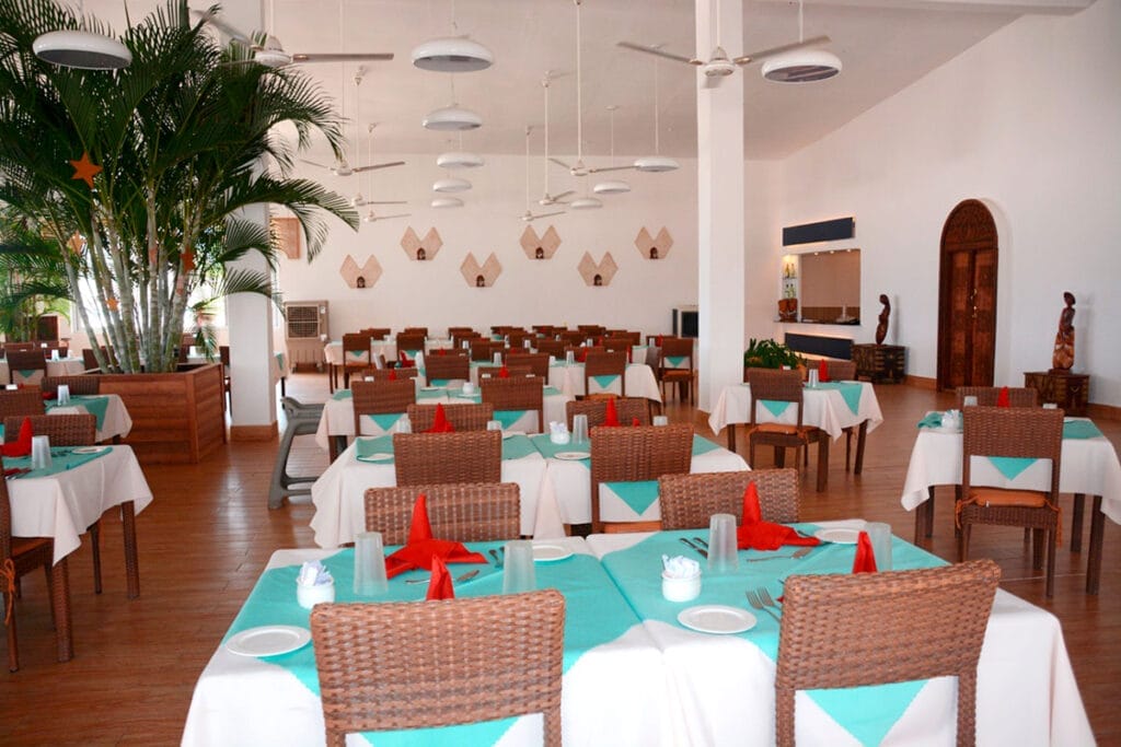 Una tovaglia bianca sul tavolo di un ristorante, accompagnata dall'atmosfera del Bravo Premium Kendwa Beach.