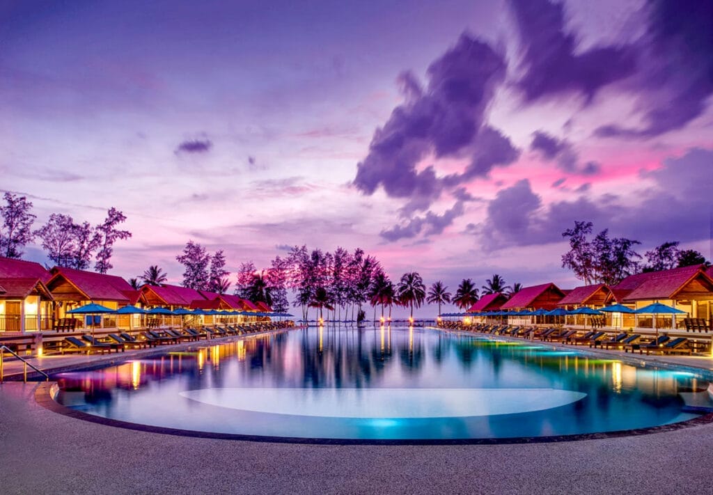 Una piscina al tramonto al Bravo Premium Khao Lak, un resort in Thailandia.