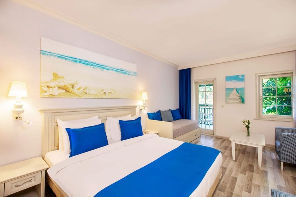 Una camera da letto bianca e blu con vista sul mare a Bodrum, Turchia.