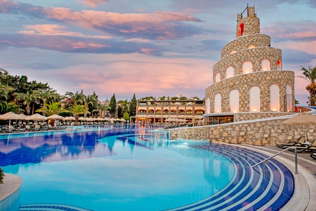 Una grande piscina con sullo sfondo la torre dell'orologio, immersa nella bellezza di Bodrum in Turchia.