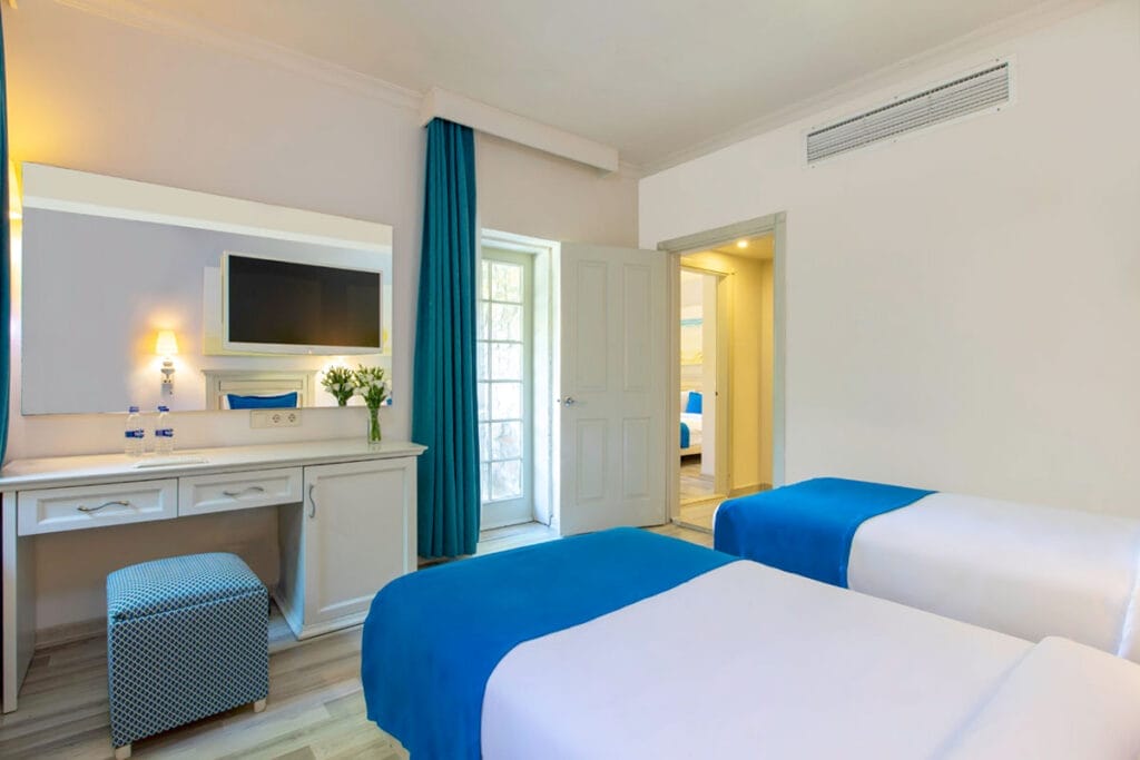 Offerta viaggio a Bodrum in Turchia, composta da una camera d'albergo con due letti e una scrivania.
