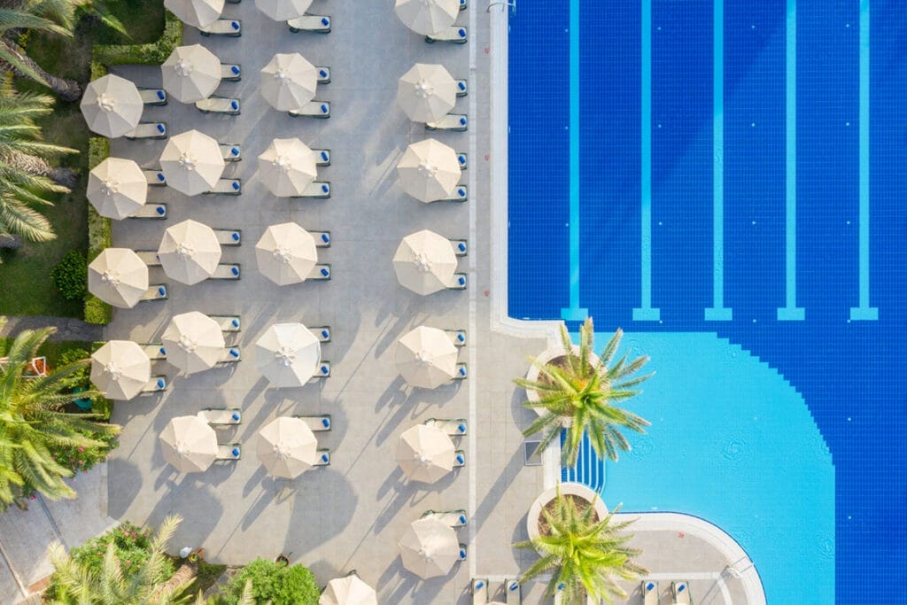 Una veduta aerea di una piscina con ombrelloni e palme a Bodrum, Turchia.