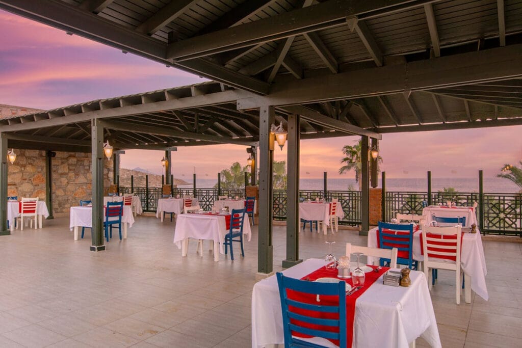 Un ristorante con tavoli e sedie che offre una vista mozzafiato sull'oceano.