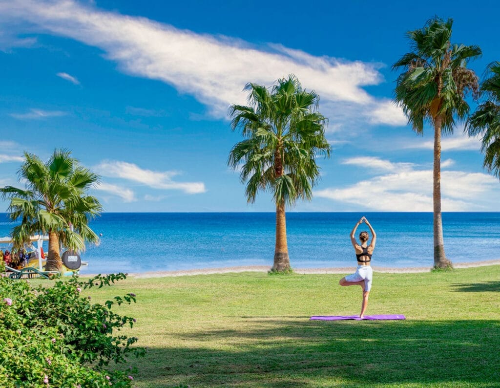 Una donna si gode una sessione di yoga su una tranquilla spiaggia in Turchia.