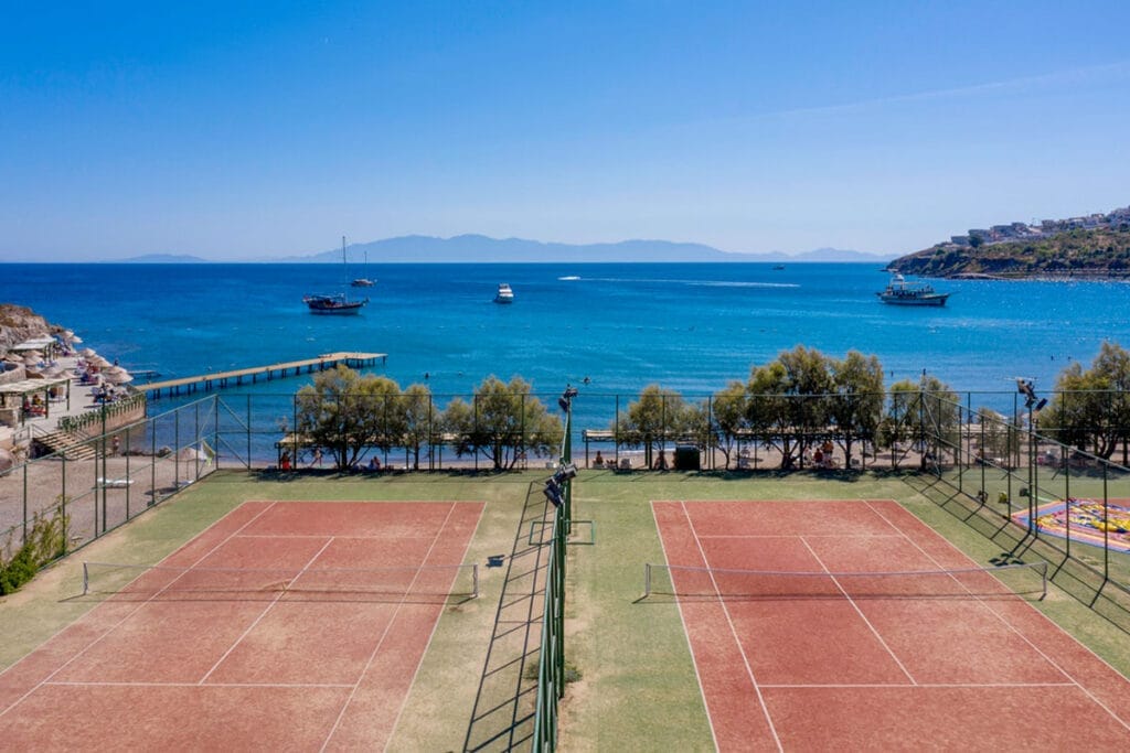Un campo da tennis con l'acqua sullo sfondo, nella splendida cornice di Bodrum in Turchia.