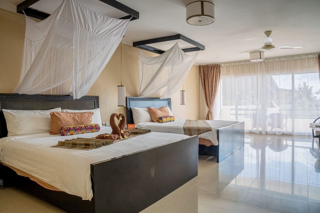 Due letti con zanzariere in una camera del Bravo Premium Kendwa Beach.