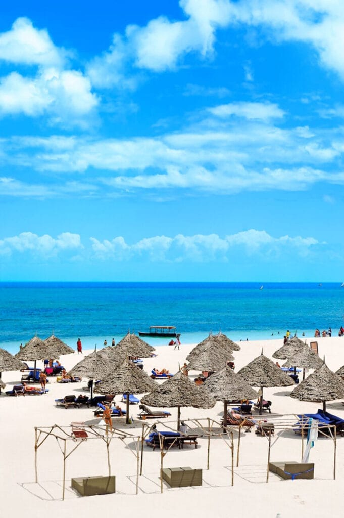 Una spiaggia sabbiosa con ombrelloni e sedie a sdraio. Perfetto per un'offerta viaggio a Zanzibar Alpitour o un'offerta viaggio SBS Viaggi. Rilassati e distenditi