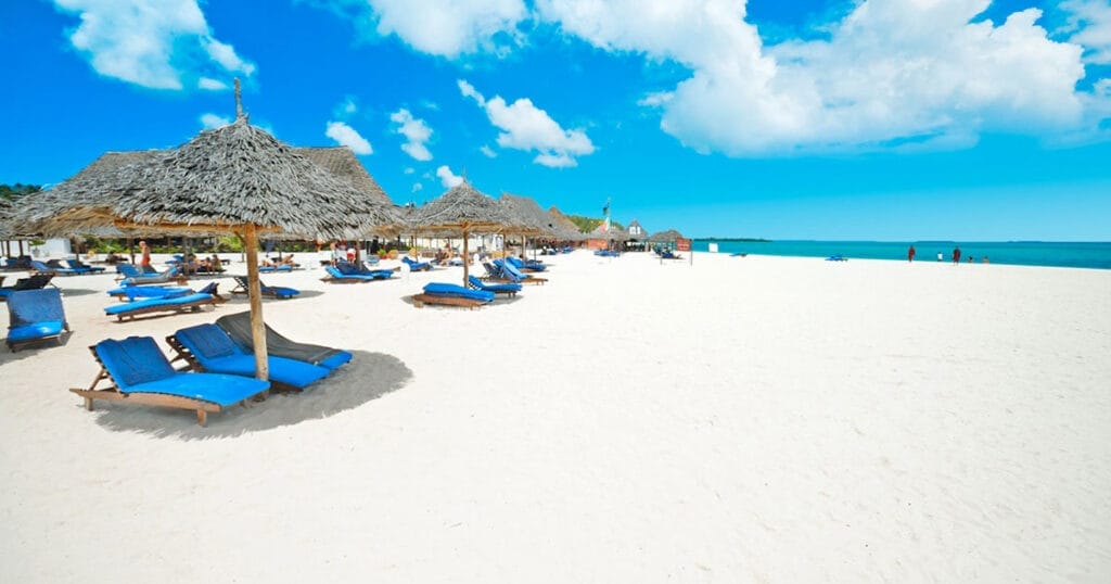 Una spiaggia attrezzata con ombrelloni e sdraio che offre il pacchetto viaggio a Zanzibar di SBS Viaggi, comprensivo di un'offerta esclusiva Alpitour. Rilassatevi al Bravo Premium Kendwa