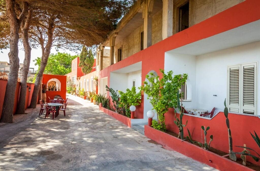 Un vicolo in Paradiso con pareti rosse e tavoli e sedie.