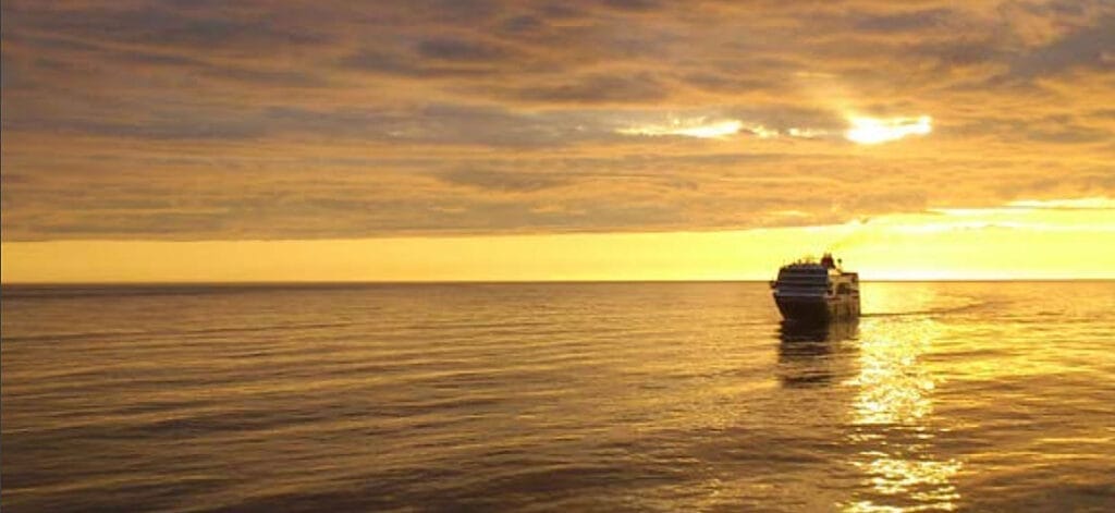 Una barca nell'oceano al tramonto durante un tour in Norvegia.
