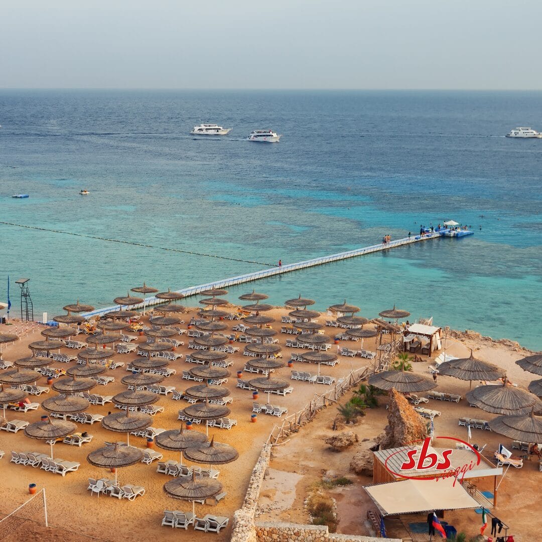 Una spiaggia attrezzata con ombrelloni e un molo è lo sfondo perfetto per una rilassante giornata al mare.