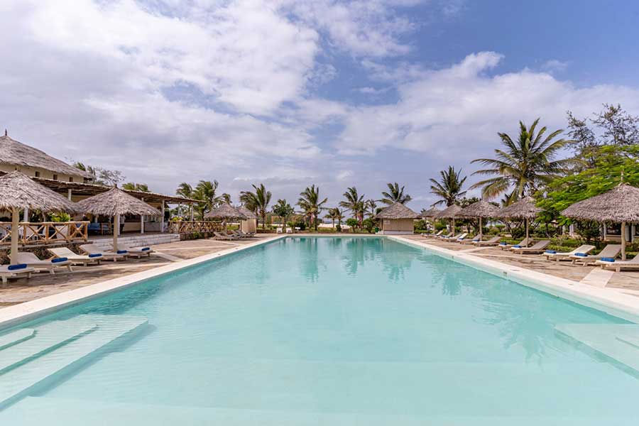 Una piscina con lettini e ombrelloni presso il 7 Islands Resort.
