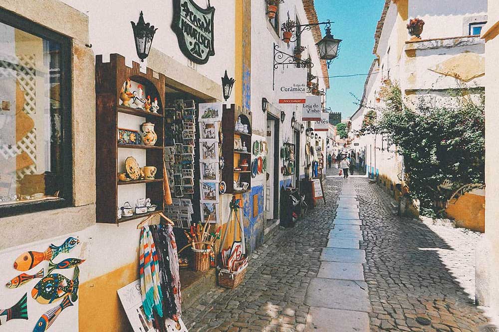 Una stretta strada acciottolata, adornata di meraviglie, in una città portoghese.