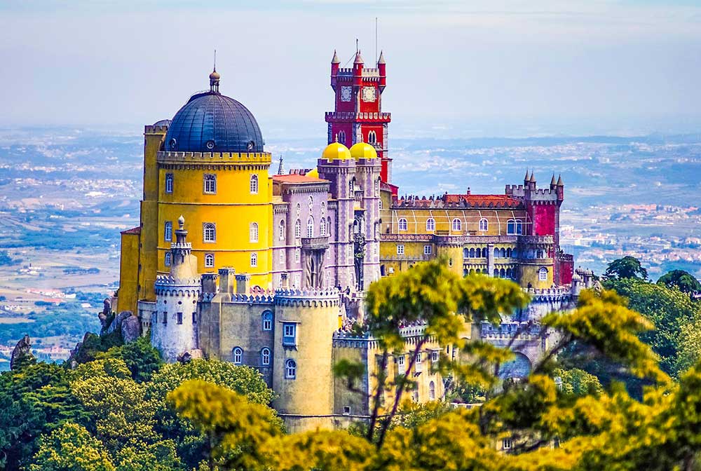 Meraviglie Tour ti porta in un castello colorato che si trova in cima a una collina in Portogallo.
