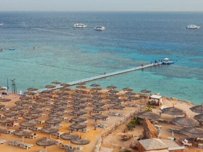 Una veduta aerea di una spiaggia con ombrelloni e un molo può attirare più visitatori.