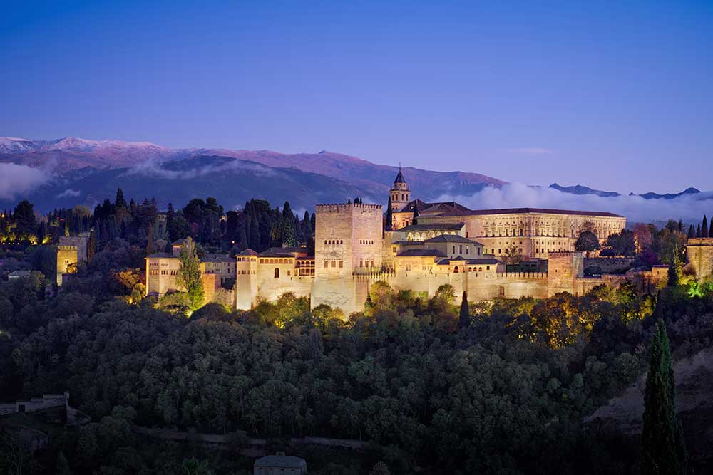 Il Tour dell'Andalusia prevede una vista mozzafiato del castello di Granada illuminato al tramonto.