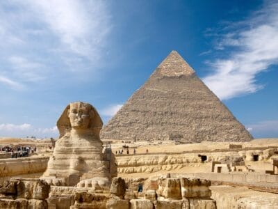 Una sfinge che sta orgogliosamente davanti ad una maestosa piramide in Egitto.