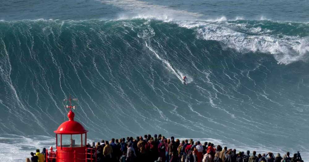 Una folla in Portogallo osserva un surfista cavalcare una grande onda durante un tour di surf di 5 giorni.