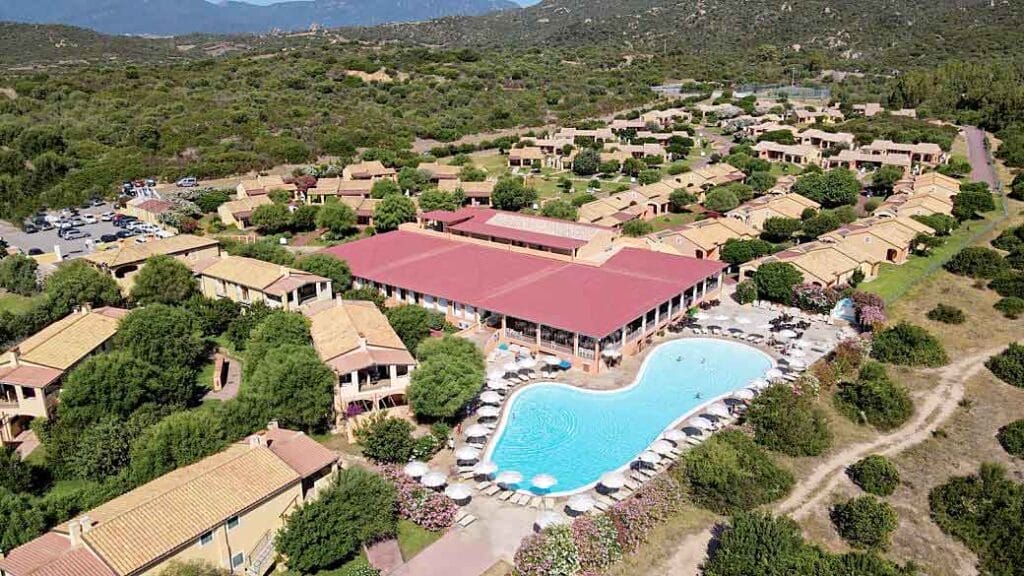 Una piscina circondata dagli edifici del Sardegna Resort.