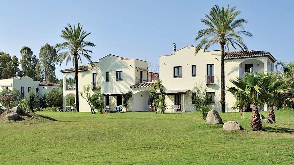 Ville in stile mediterraneo immerse in curati giardini con palme vicino a Marina Torre Navarrese.