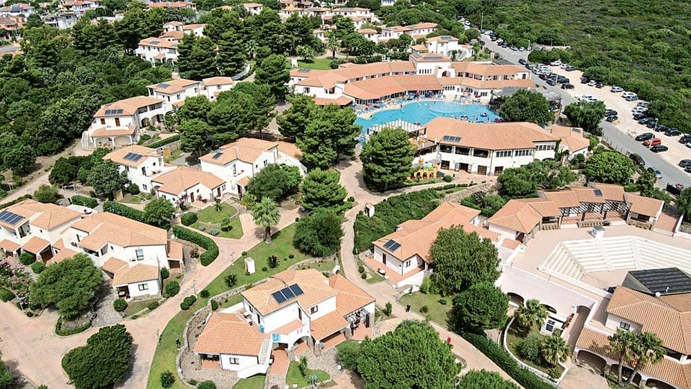 Veduta aerea del Club Esse Cala Gonone, resort con piscina circondato da ville bianche nel verde della Sardegna.