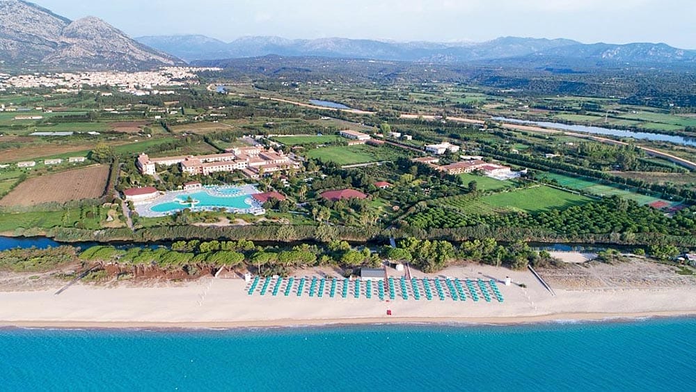 Veduta aerea del Marina Resort con piscina e file di ombrelloni in riva al mare.
