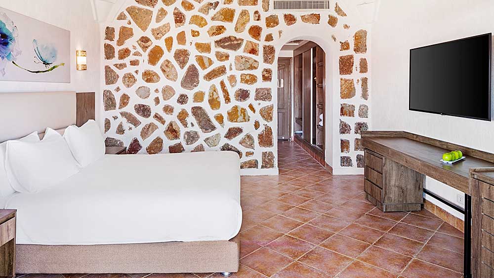 Camera d'albergo moderna con pareti in pietra, arredamento minimalista e un'esclusiva offerta viaggio Marsa Alam al Villaggio Mar Rosso.