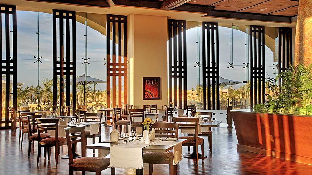 Spaziosa sala da pranzo con arredamento moderno e ampie finestre che offrono una vista sull'esterno al Villaggio Mar Rosso.