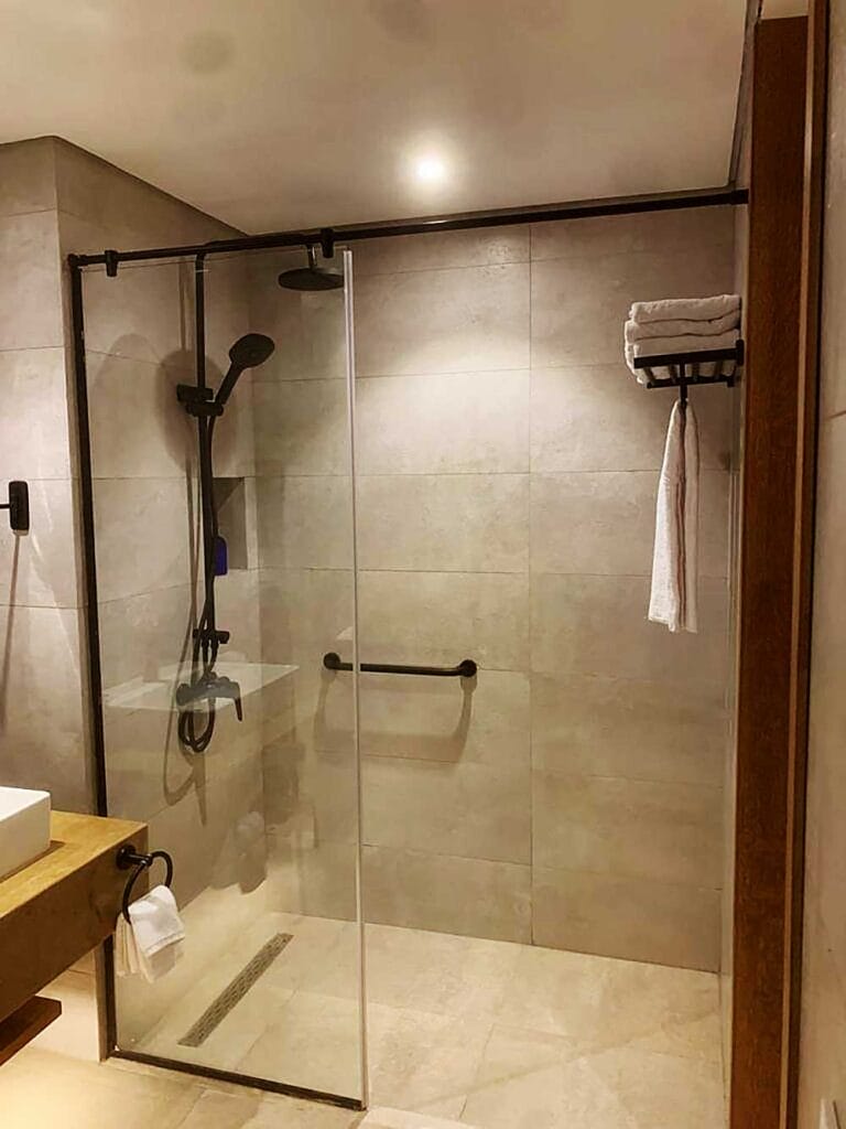 Un bagno moderno con cabina doccia in vetro e piastrelle beige al Villaggio Sharm El Sheikh.