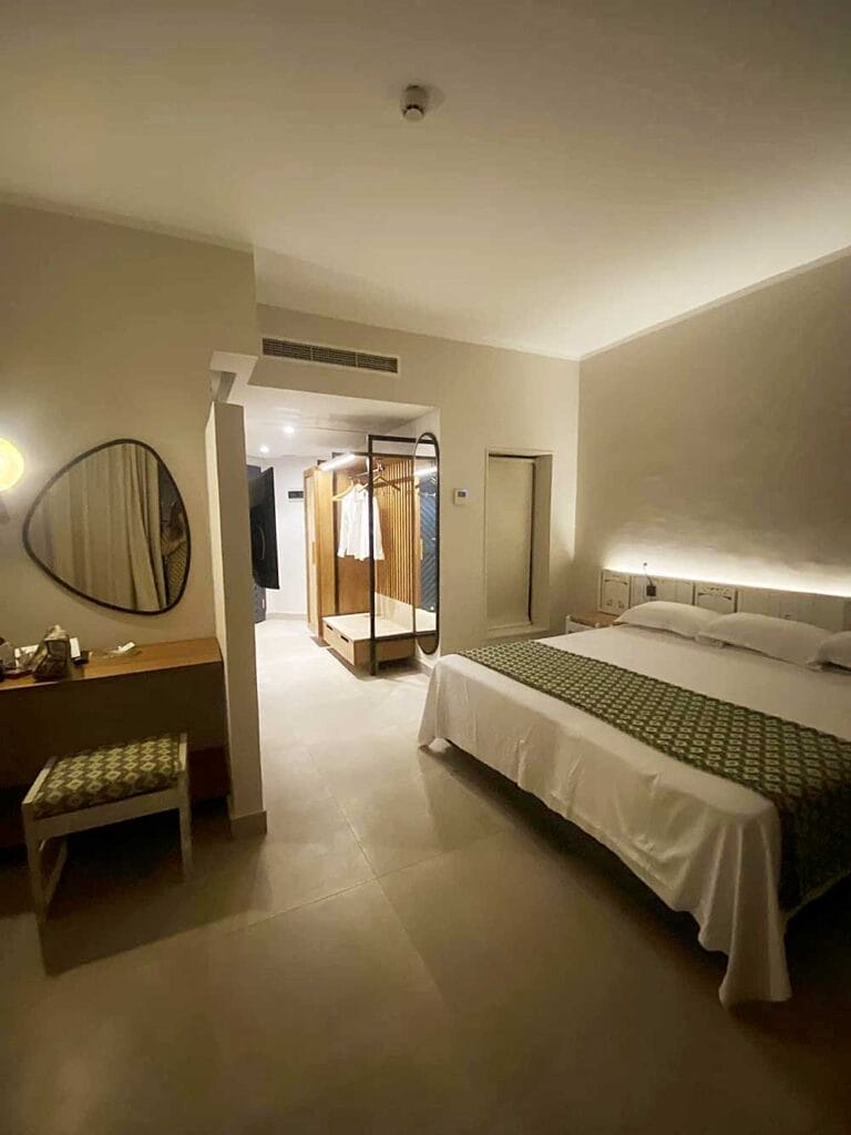 Una camera ben illuminata e ordinata al Villaggio Sharm El Sheikh, dotata di letto, comodini e armadio a specchio.