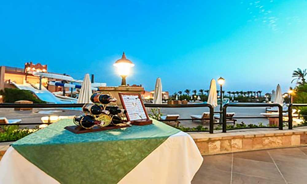 Tavola apparecchiata per la cena con vista sul Villaggio Mar Rosso e sullo sfondo l'acquascivolo.