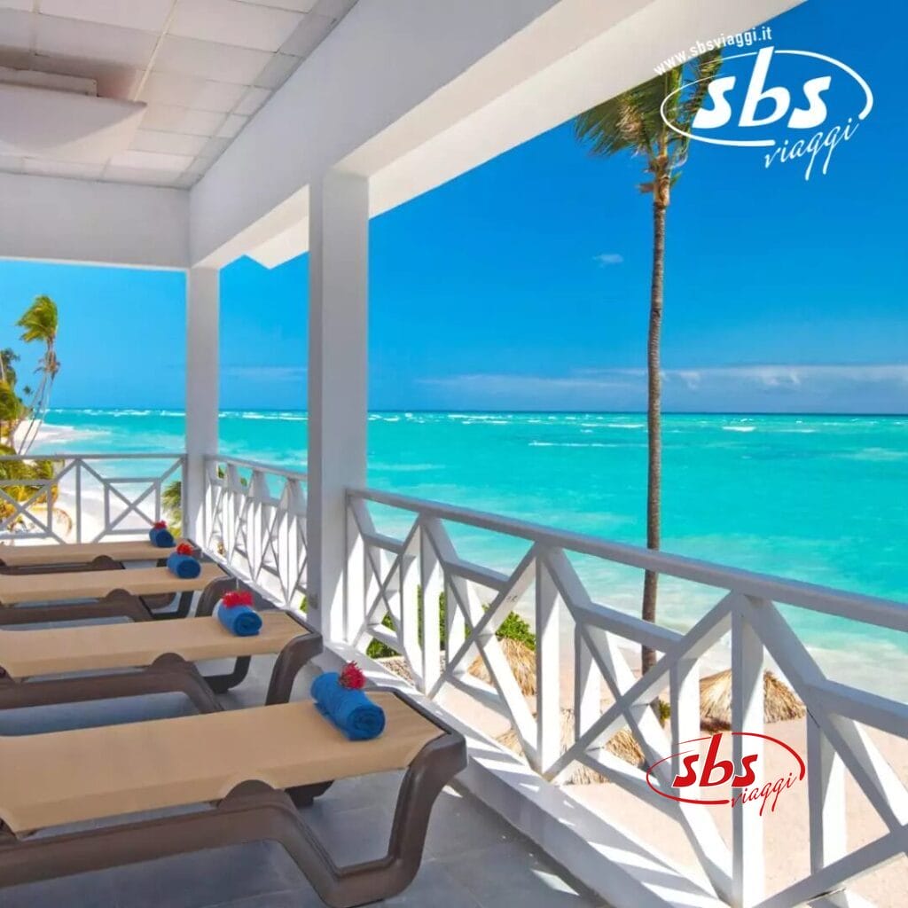 Patio fronte mare al Whala! Bavaro con sedie a sdraio con vista sull'oceano turchese e sulle palme sotto un cielo azzurro e terso.