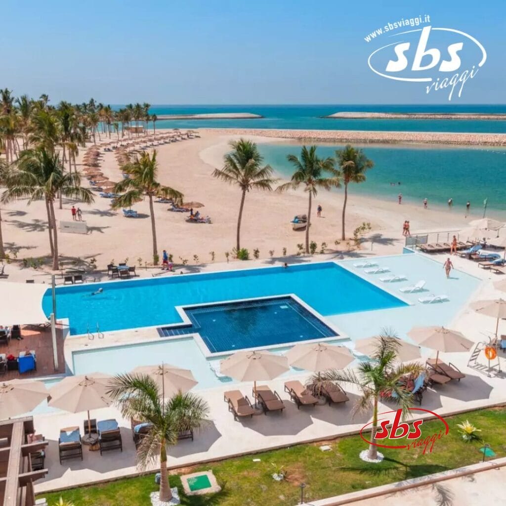 Seaclub Fanar: un resort sulla spiaggia con una grande piscina, lettini prendisole e palme con vista sull'oceano.