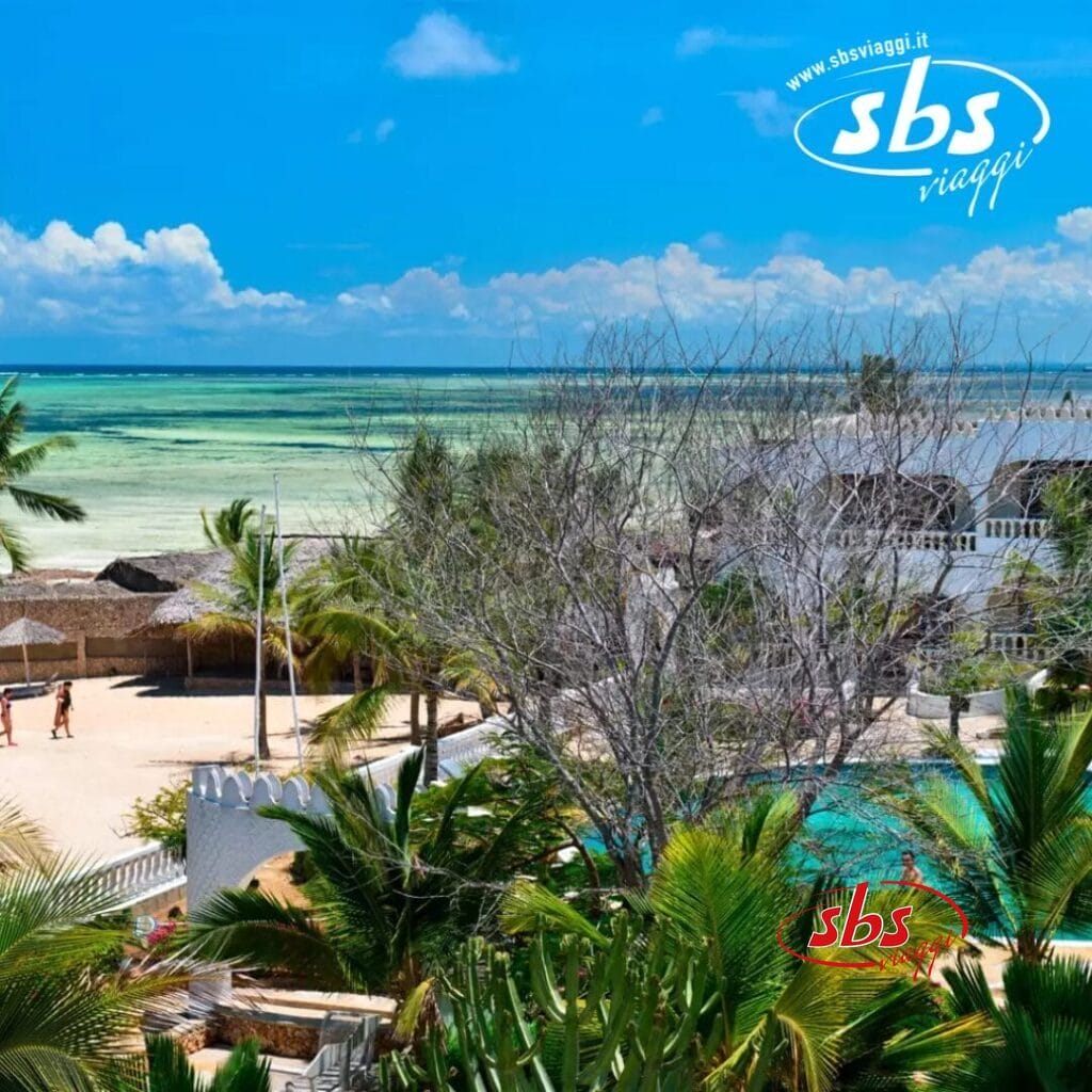 Scena di fronte alla spiaggia in un resort gigante con piscina circondata da palme, con vista sull'oceano sotto un cielo azzurro e terso. Logo 