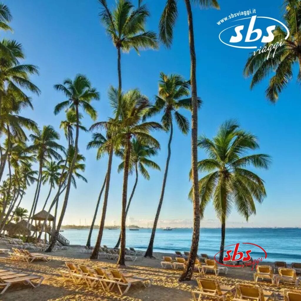 La spiaggia tropicale dell'Hilton La Romana vanta palme, lettini prendisole e un mare calmo sotto un cielo azzurro e limpido: il resort perfetto per una vacanza in famiglia.