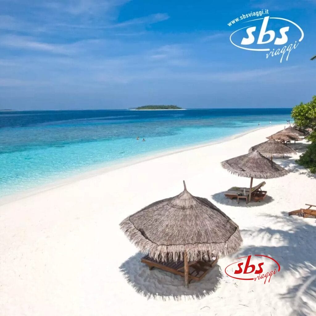 Spiaggia soleggiata con sabbia bianca, acqua turchese e ombrelloni di paglia al Reethi Faru Resort. Due persone nuotano in lontananza, mentre una piccola isola è visibile all'orizzonte.