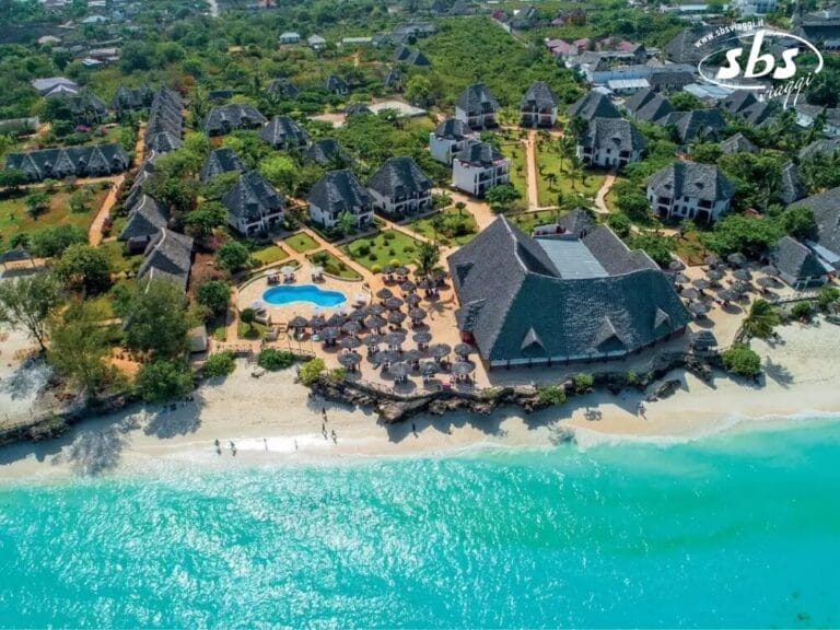 Vista aerea del resort Sunset Beach del Veraclub, con edifici dal tetto di paglia, una piscina centrale e le splendide acque turchesi dell'oceano.