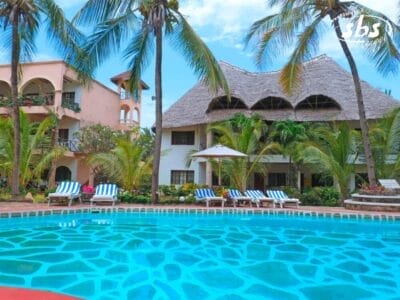 Un paradiso tropicale, l'Aquarius Club offre una grande piscina circondata da palme e lettini prendisole. Sullo sfondo, un edificio con tetto di paglia e una struttura a più piani con balconi aggiungono fascino a questo esclusivo resort internazionale.