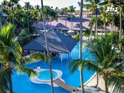 Uno splendido resort sulla spiaggia a Punta Cana vanta una grande piscina, circondata da palme e affascinanti edifici con tetto di paglia. Questo paradiso tropicale, completo di una piccola isola circolare al centro, offre una fuga serena a pochi passi da un'esperienza spa di livello mondiale.