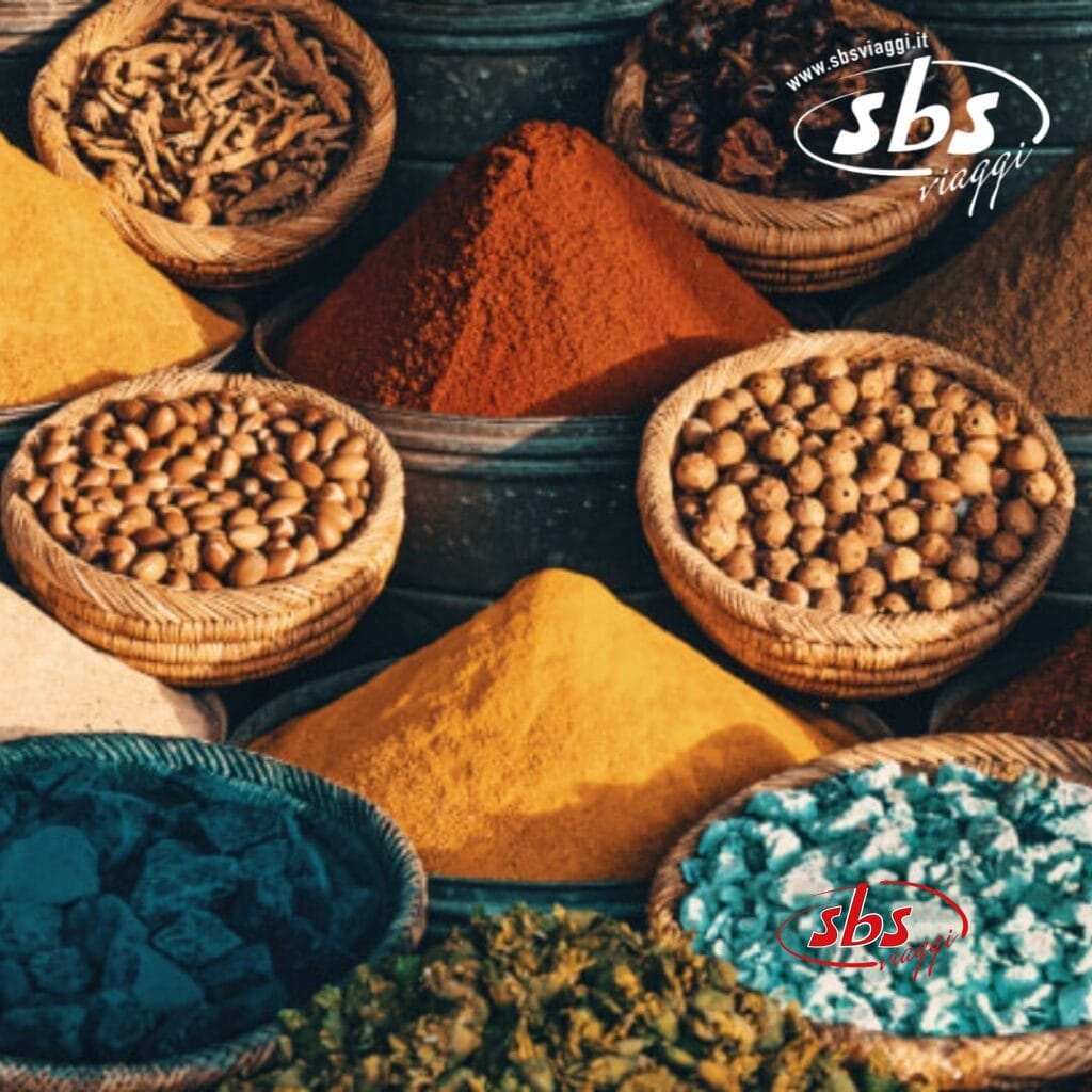 Cestini di spezie colorate e noci in un mercato, che ricordano il fascino esotico del Marocco Imperiale, con mucchi di polveri e semi colorati esposti in una serie.