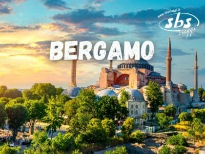 Vista panoramica di una grande moschea con minareti, circondata da alberi verdi, sotto un vivace cielo al tramonto. Il testo in grassetto recita "Bergamo Tour" con un logo di viaggio nell'angolo, che ti invita a esplorare le meraviglie della Turchia.