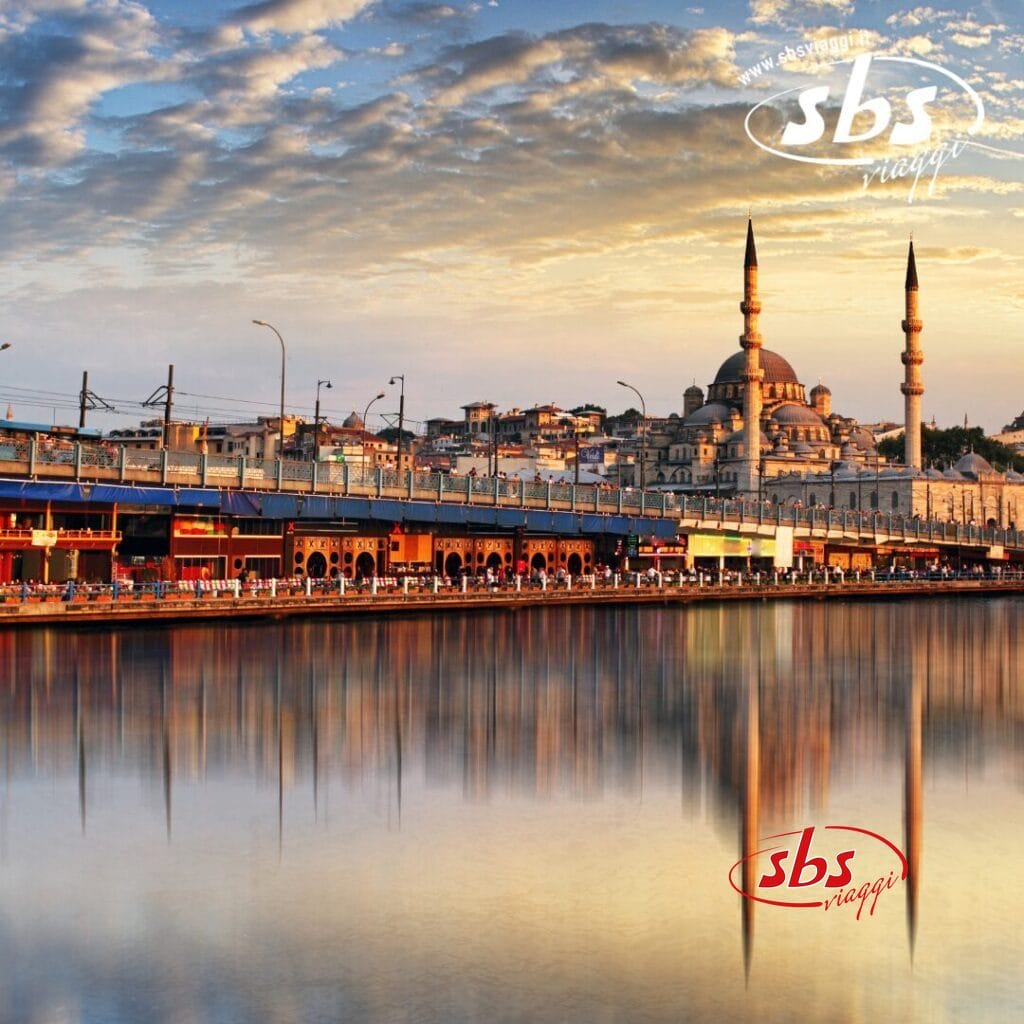 Esplora lo straordinario ponte sul fiume con i suoi riflessi perfetti, vicino a un paesaggio urbano accentuato da una grande moschea con due minareti al tramonto. Questa scena pittoresca ricorda il Tour Turchia o addirittura evoca il fascino di Bergamo.